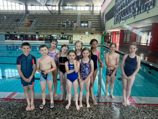 3rd grade students posing in a pool after a competition.